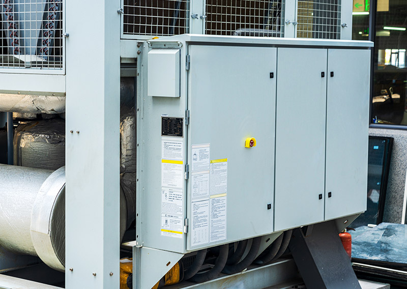An industrial commercial HVAC chiller system with integrated electrical controls, utilizing active harmonic filters to prevent motor insulation degradation and premature bearing wear.