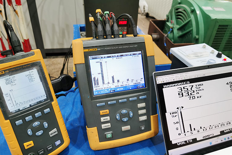 Engineer using a handheld power quality analyzer to measure harmonic distortion in a facility