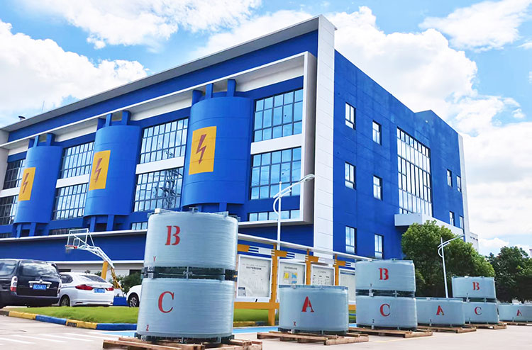 Air-core current limiting reactors displayed outside an industrial manufacturing facility.