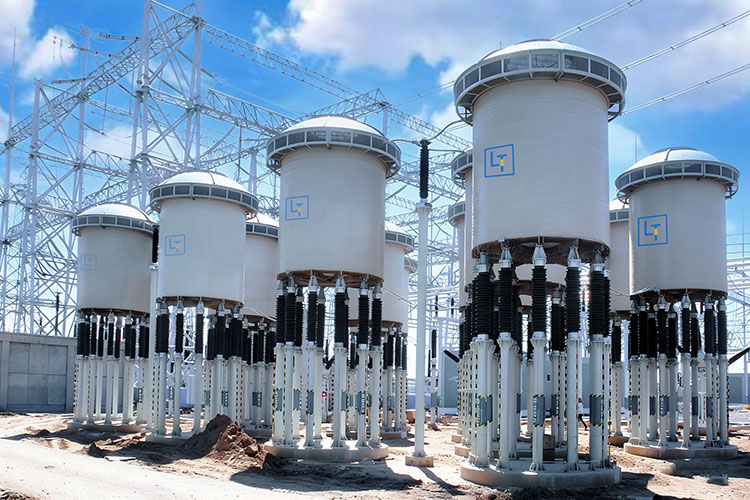 High-voltage outdoor current limiting reactors installed in an industrial substation for power system protection.